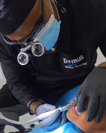 Médico dentista da Domus com lupas de aumento durante um tratamento